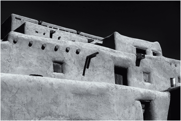 A black and white photograph of an adobe building.