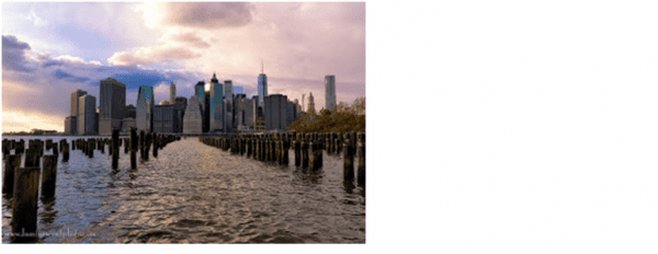 The skyline of new york city is seen from the water.