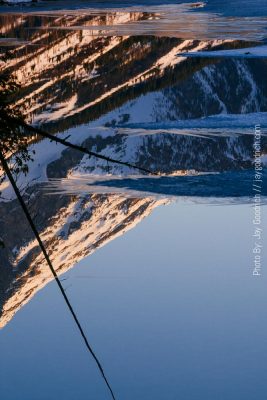 A mountain is reflected in a body of water.