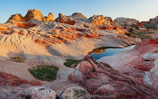 A red rock formation with a lake in the middle.