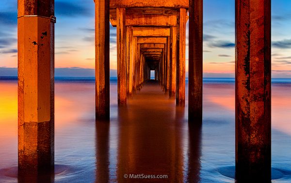 A pier under the water at sunset.