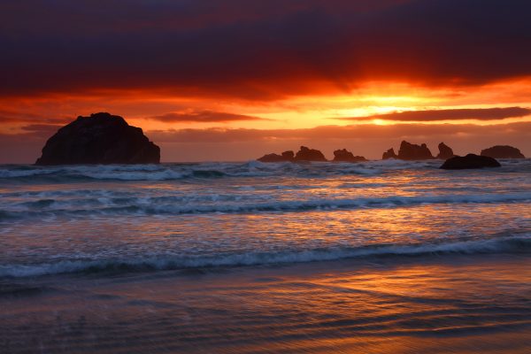 Sunset over ocean with rocky islands.