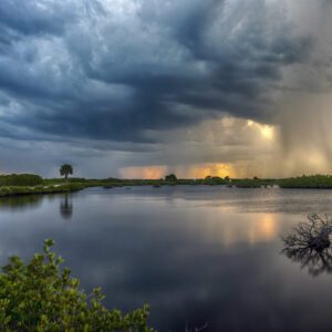 Calm lake with storm clouds and sunrays.