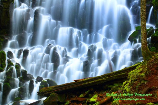 Waterfall flowing over mossy rocks.