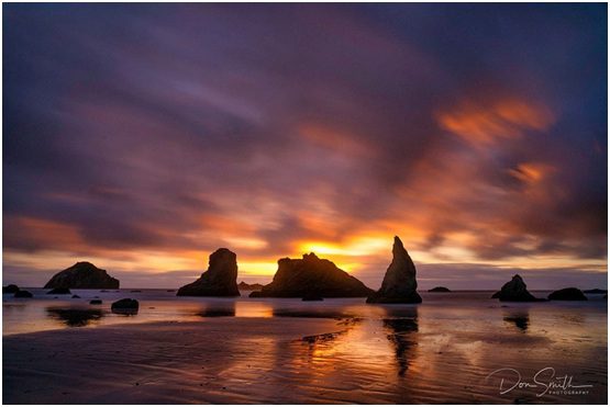 Sunset over sea stacks on the beach.