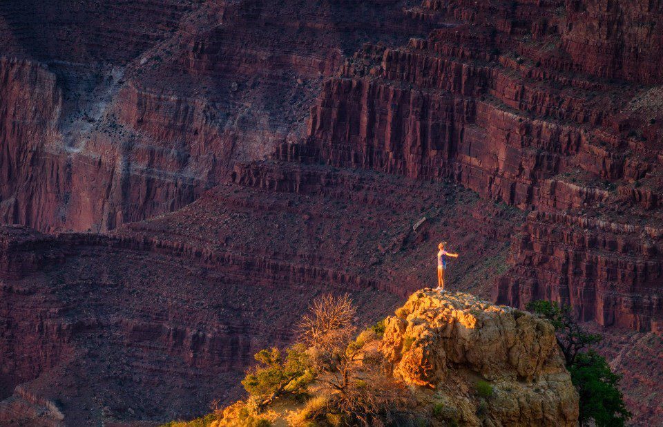 Woman overlooking Grand Canyon cliffs.