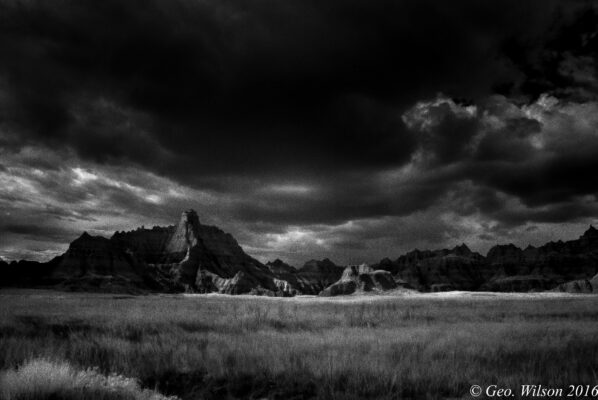 Black and white landscape of rocky hills.