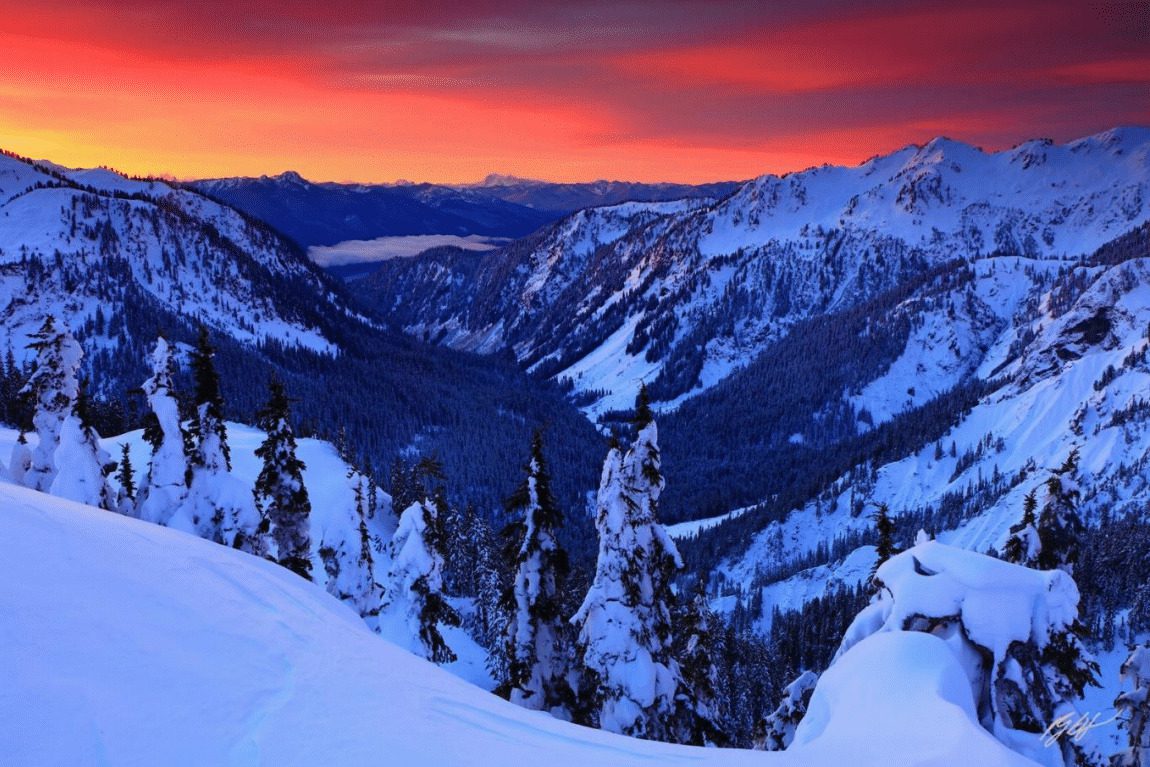 Snowy mountain range at sunset.