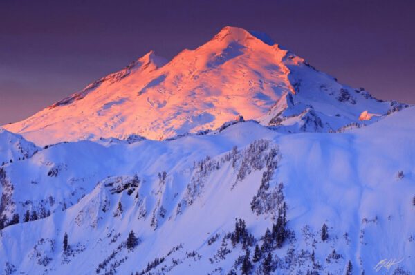 Snowy mountain peak at sunrise.